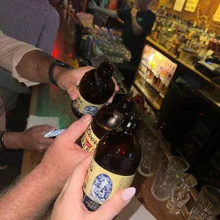 a man holding two bottles of beer