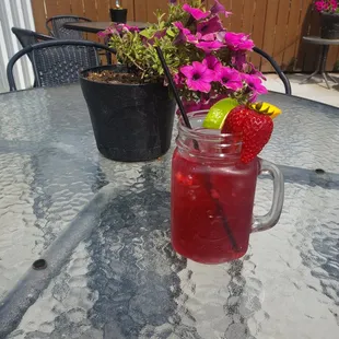 a glass of drink with a strawberries garnish