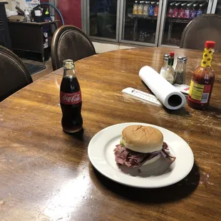 Polish sandwich with onions, mustard, and pickle on a regular bun.