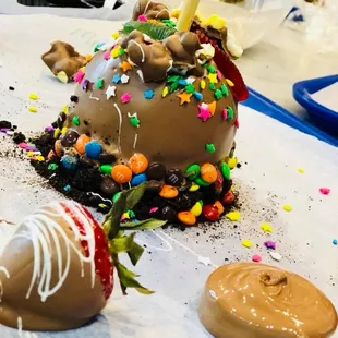 A strawberry, an oreo, and an apple dipped in chocolate and decorated.