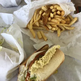 A huge bag of french fries with one onion ring extra little treat