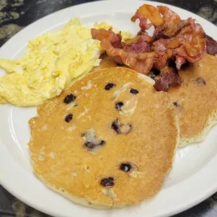 Blueberry pancakes, eggs, and bacon