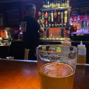 a glass of beer on a bar