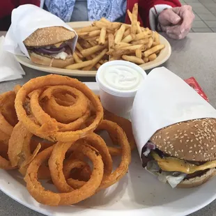 Cheeseburger with onion rings and cheeseburger with fries.