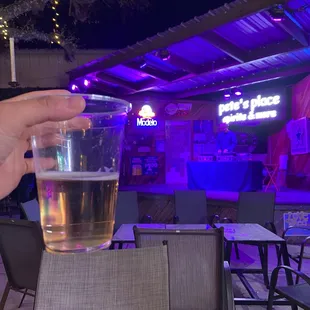 a person holding a glass of beer