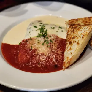Lasagna half red half white with garlic bread
