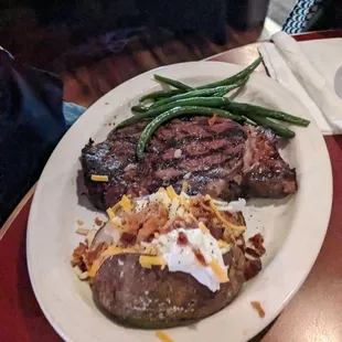 Ribeye steak with loaded baked potato and green beans
