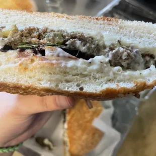 a person holding a half eaten sandwich