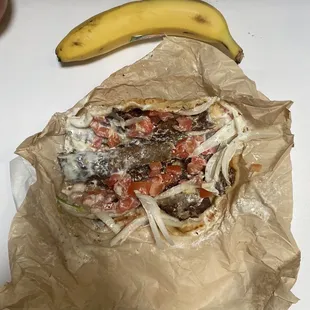 a burrito and a banana on a table
