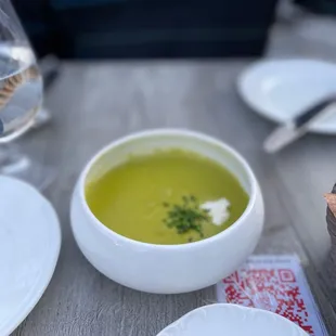 a bowl of soup and a slice of cheese