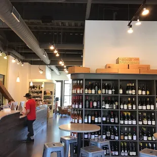 a man standing at a counter in a wine shop