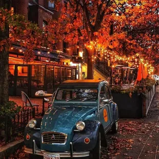 a blue car parked on the sidewalk