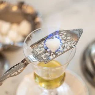 Absinthe, Paris' favorite drink, served with a water drip on a silver "green fairy" statue.