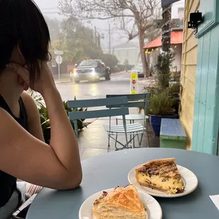 a woman sitting at a table with two slices of pizza