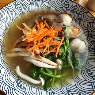 Egg noodle soup with chicken broth topped with roasted pork, mushrooms and fish balls