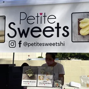 a woman behind a display of pastries