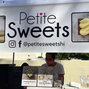 a woman behind a display of pastries