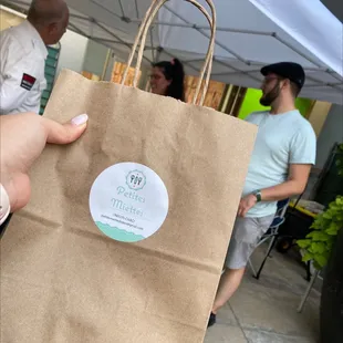 a person holding a brown paper bag