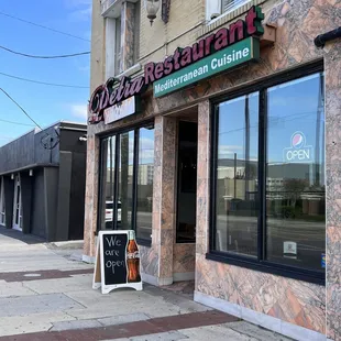 the front of a restaurant with a sign on the sidewalk
