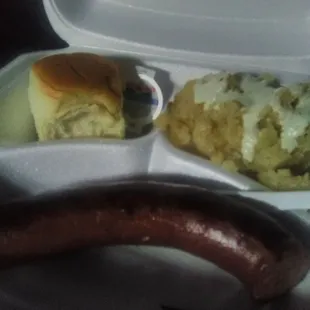 Sausage link, baked potatoes and a sweet roll