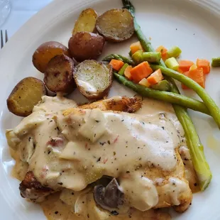 a plate of food with chicken, potatoes, and asparagus