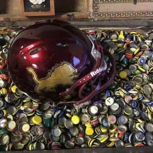 a football helmet in a chest full of beer caps