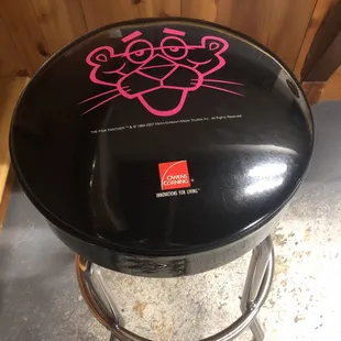 a black stool with a pink logo