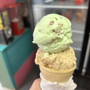 a hand holding a cone of ice cream