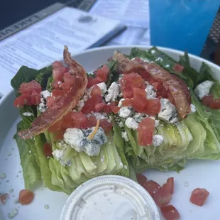 Wedge salad with romaine hearts, bacon, tomato, bleu cheese crumbles and dressing! Yum!