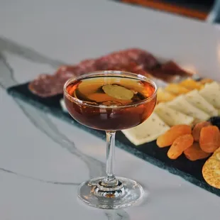 a platter of cheese, crackers, olives, and crackers