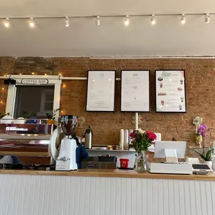 a coffee shop with a brick wall