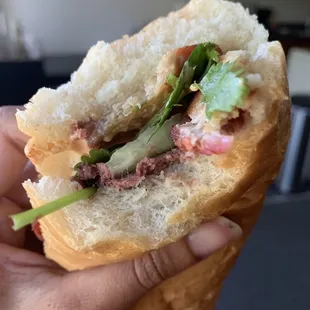 a hand holding a sandwich