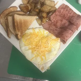 Turkey bacon, house fries, eggs and cheese on top with white toast