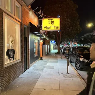 a man walking down a sidewalk at night