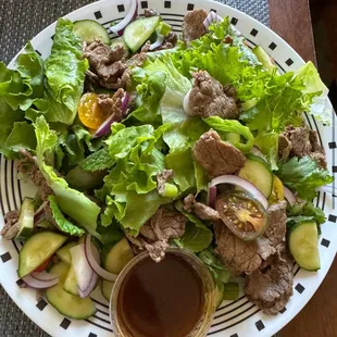 a plate of salad with meat and vegetables