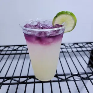 a purple and white drink with a lime slice