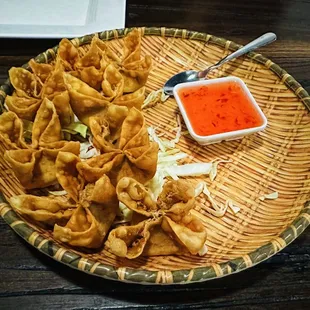 a plate of wontons with dipping sauce