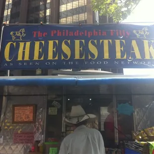 a man standing in front of a food stand