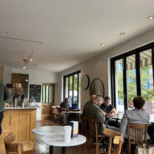 people sitting at tables in a cafe