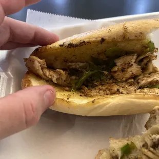 a hand holding a sandwich