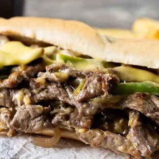 a beef sandwich with pickles and cheese