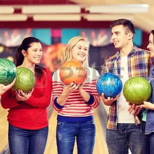 a group of people holding bowling balls