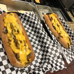 two hot dogs covered in cheese