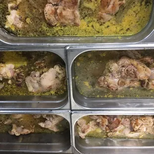 four pans of chicken in broth