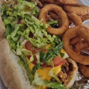 a sandwich with onion rings and lettuce
