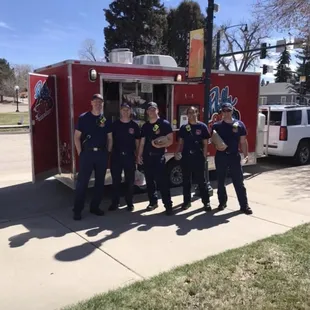 a group of people standing in front of a fire truck