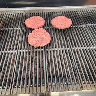 Fresh angus chuck beef patties on grill