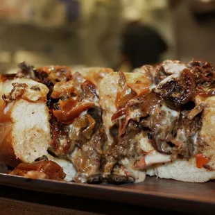 Ribeye cheesesteak with "the works" which includes  fried onions, roasted bell peppers, and sautéed mushrooms