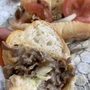 Philly cheesesteak with tomato, lettuce, and grilled onions