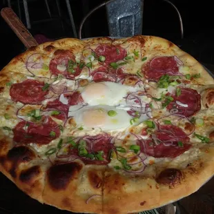 Breakfast pizza: white sauce feta cheese parmesan mozzarella red onions sopressata and two fried eggs... topped with garlic oil!!